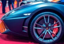 Szczegółowy widok koła luksusowego samochodu sportowego na czerwonym dywanie na pokazie samochodowym.